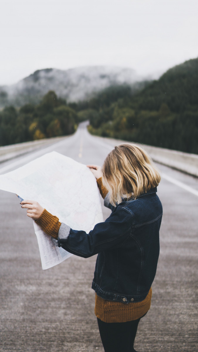 Woman on road looking at map